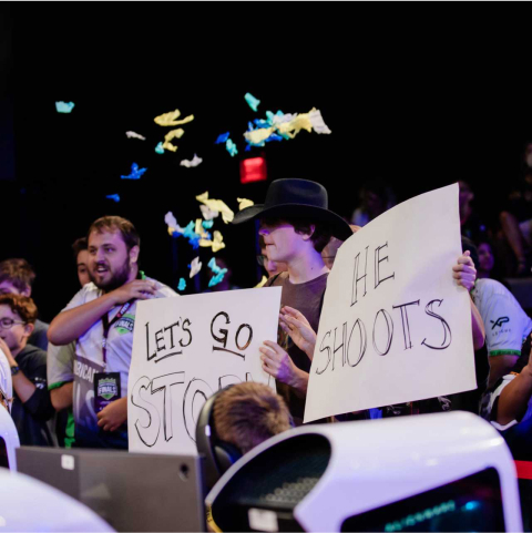 boys holding gaming league signs